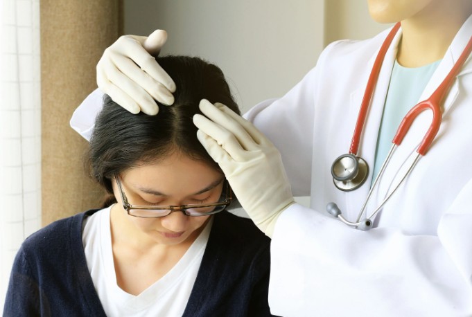 When should you see a specialist for persistent dandruff?